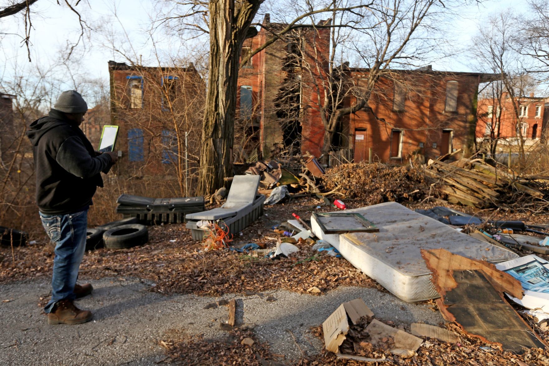 Tony Stokes documents trash and debris with his city-issued tablet
